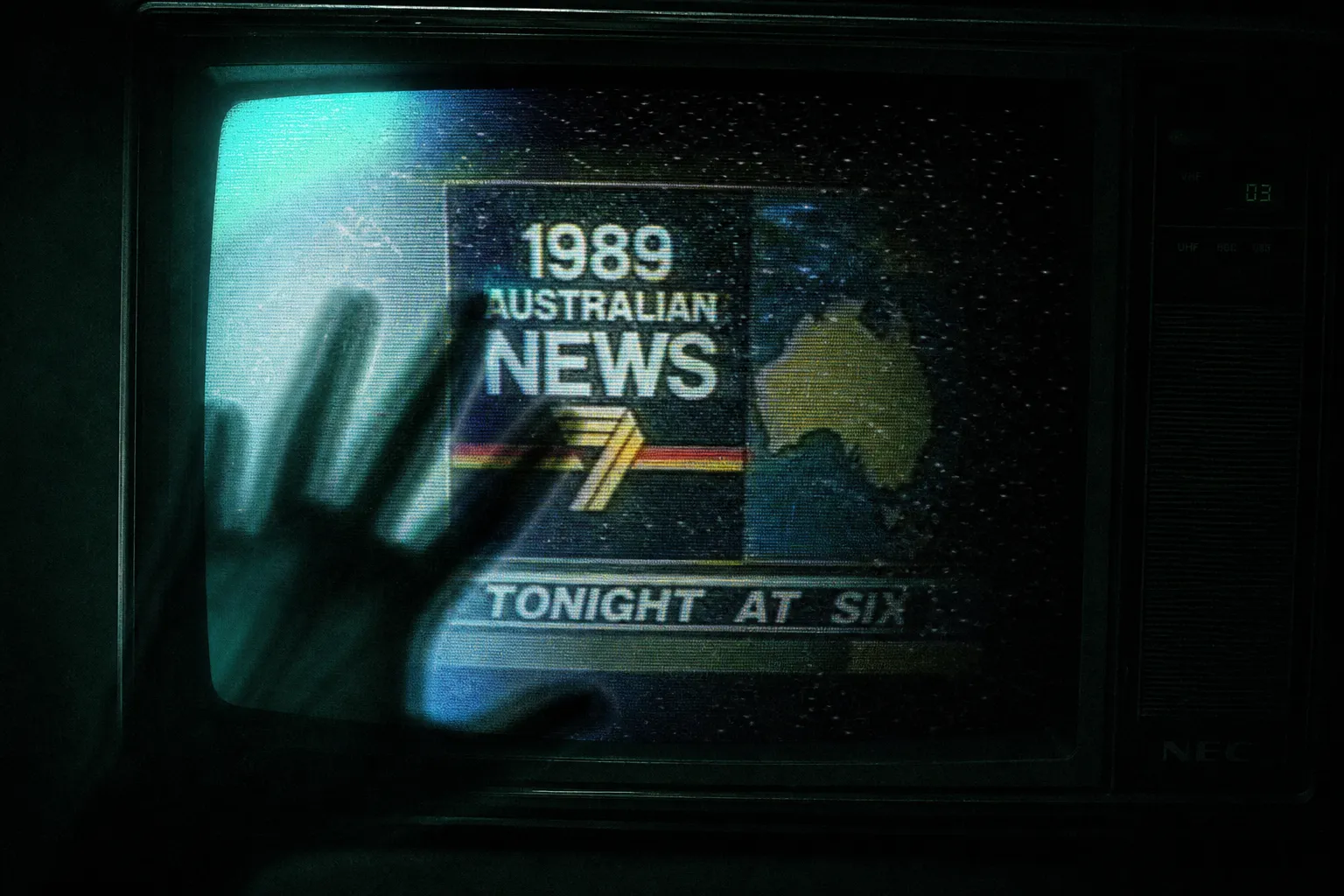A person holding a small CRT television broadcasting distorted news footage