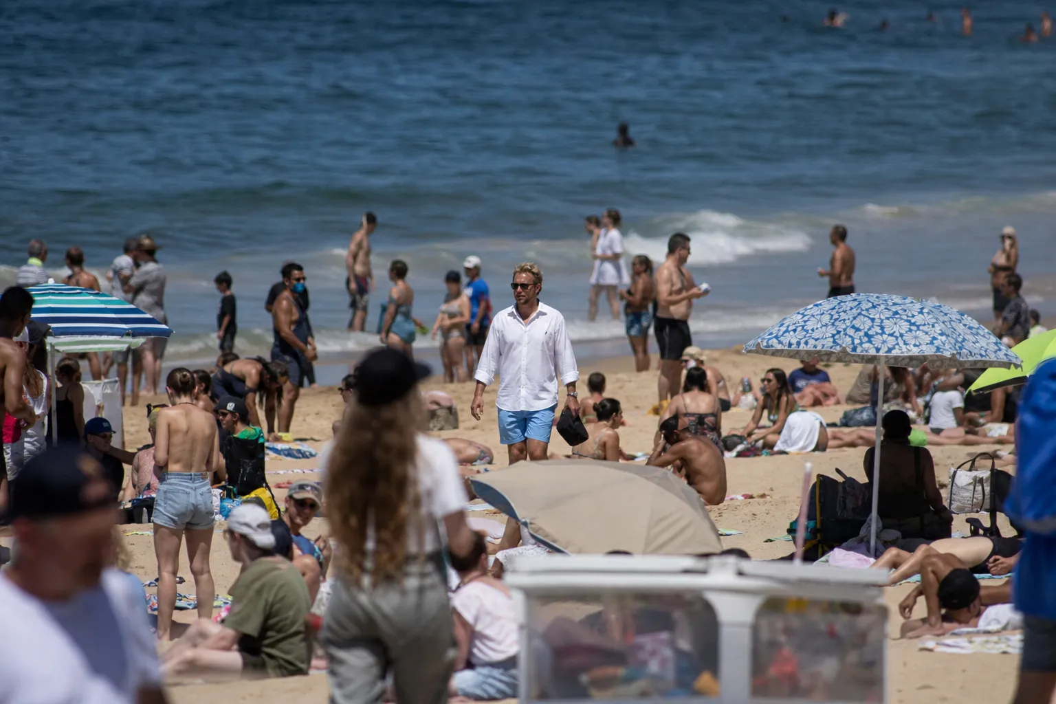 Telephoto surveillance photograph of a blond white person singled out on Cronulla Beach